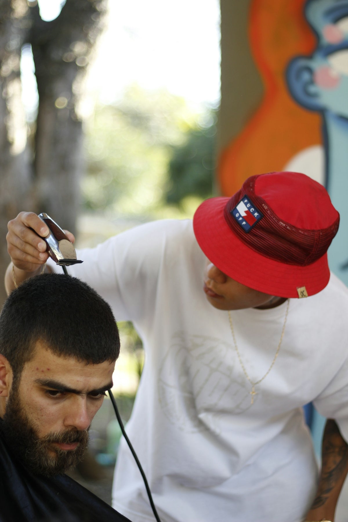 man wearing white shirt holding hair clipper